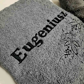 szary ręcznik z czarnym haftem imieniem Eugeniusz